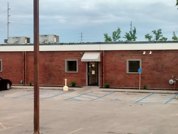 Single-story brick building with a white awning and accessible parking spaces.