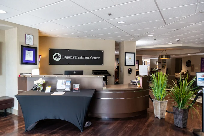 Reception desk with signage, plants, and information table