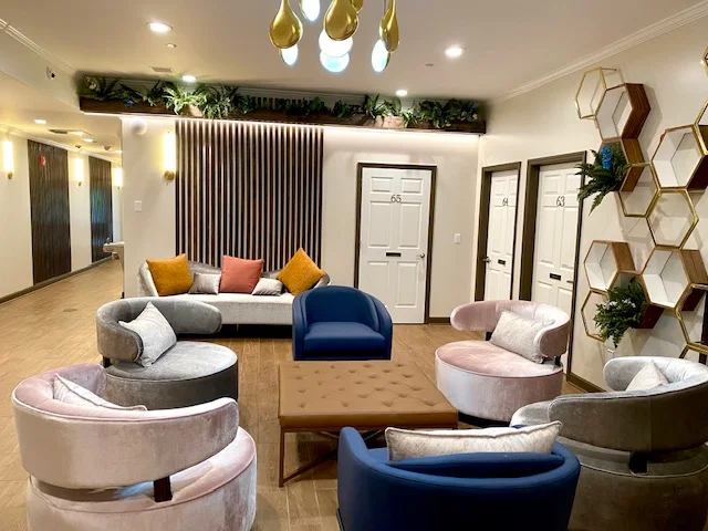 Seating area with orange couch and window view of pool