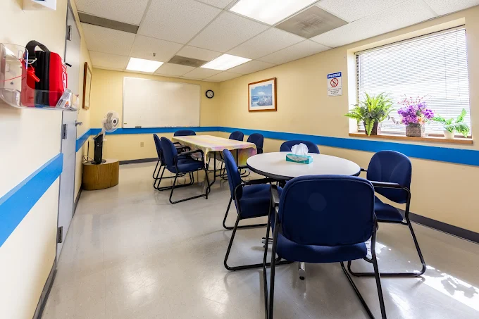 Therapy room with tables, blue chairs, and natural light
