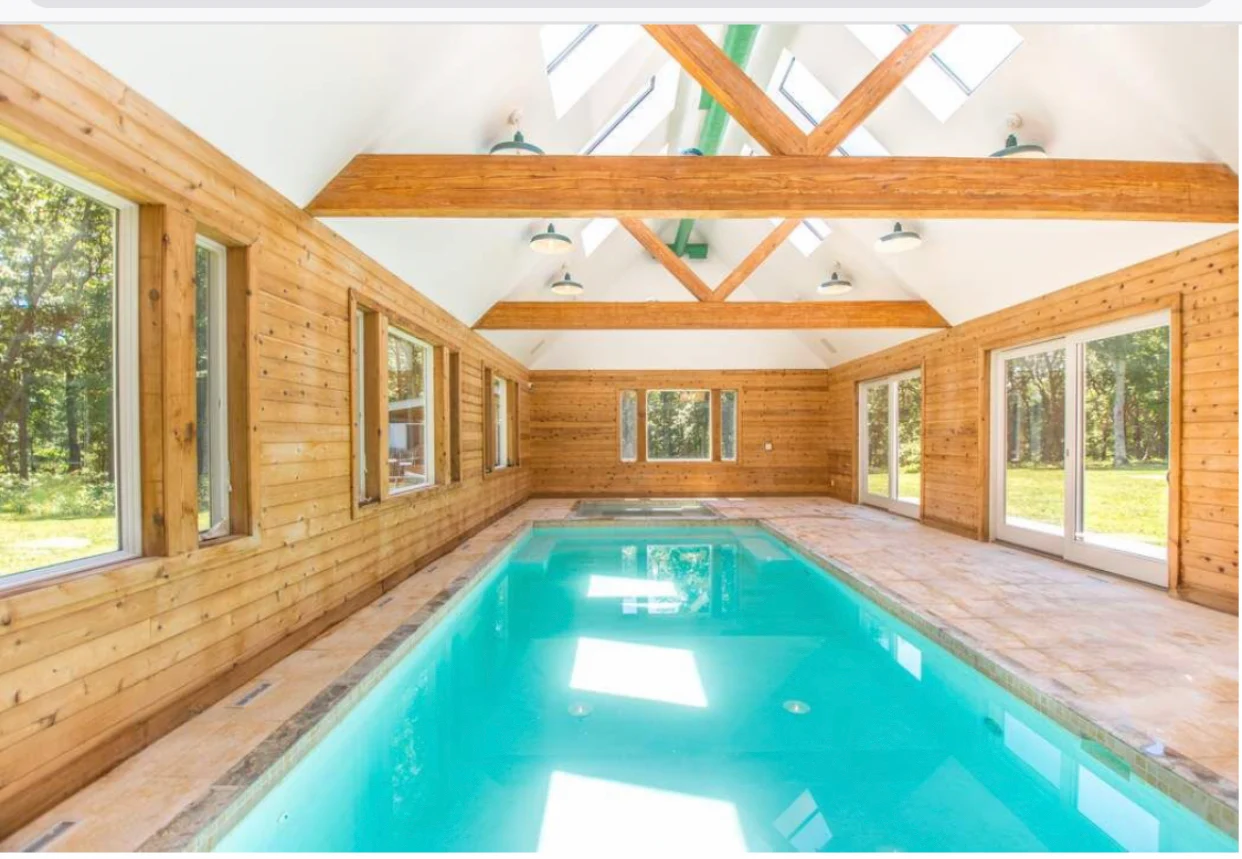 Indoor pool with wooden walls and skylights