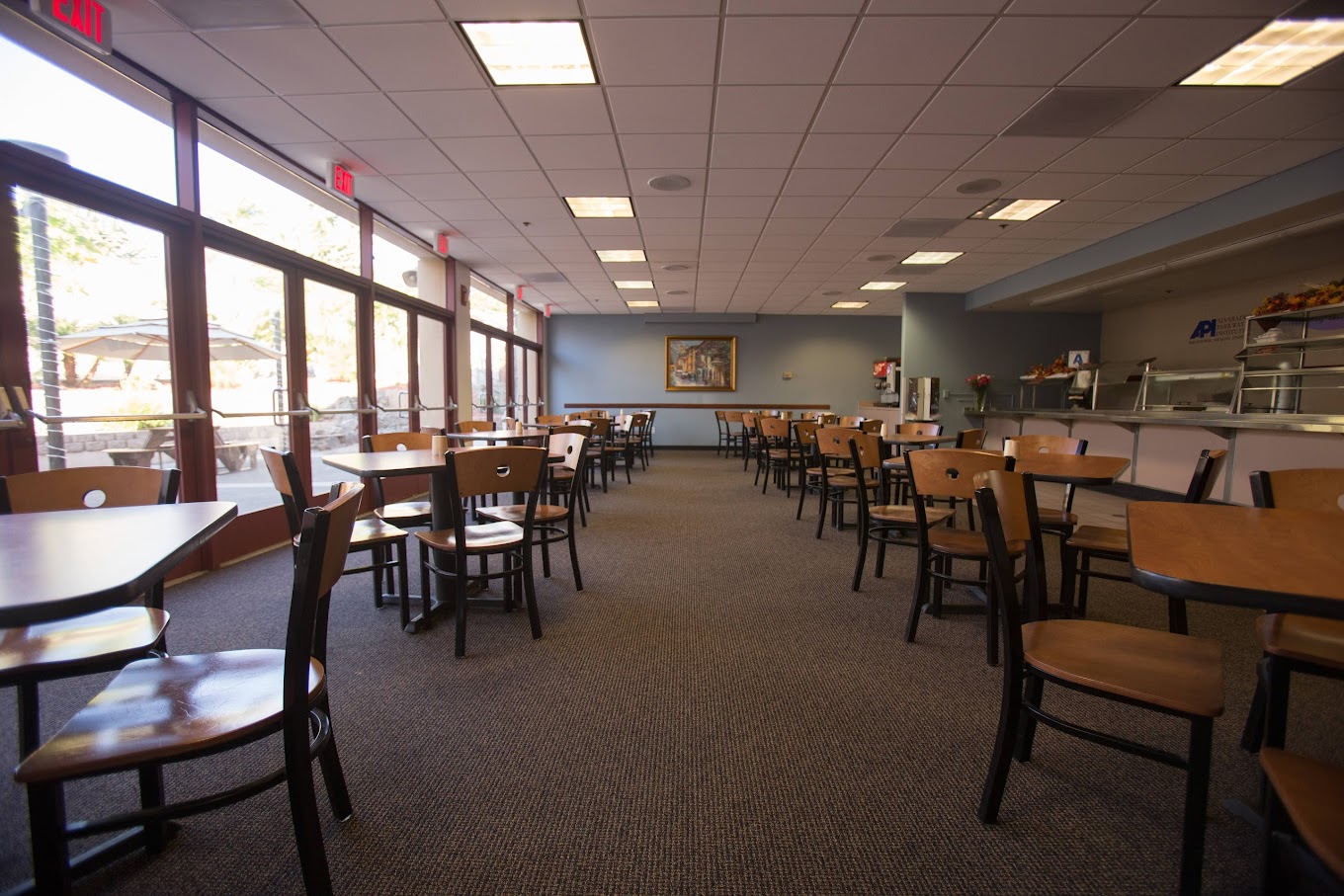 A spacious and bright dining area with plenty of seating and large windows, offering a pleasant and comfortable atmosphere for meals.