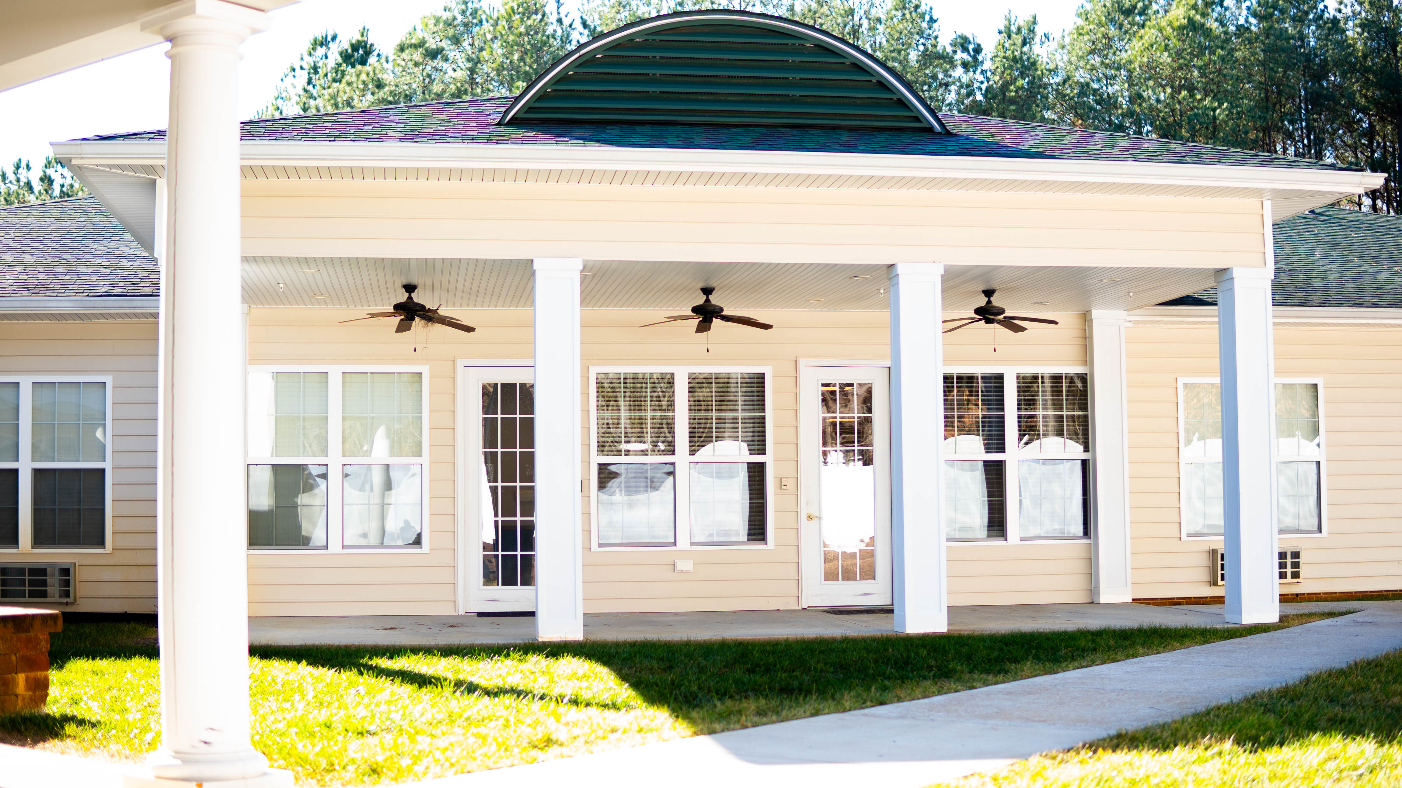 Outdoor patio with white columns and ceiling fans.