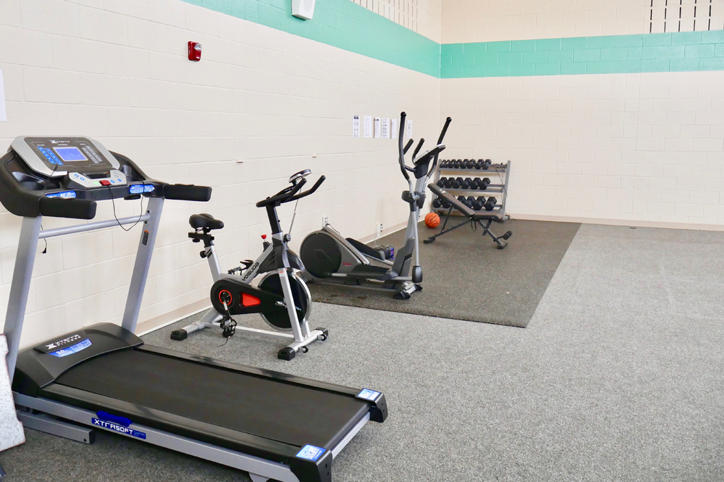 Fitness room with treadmill, bikes, and weights
