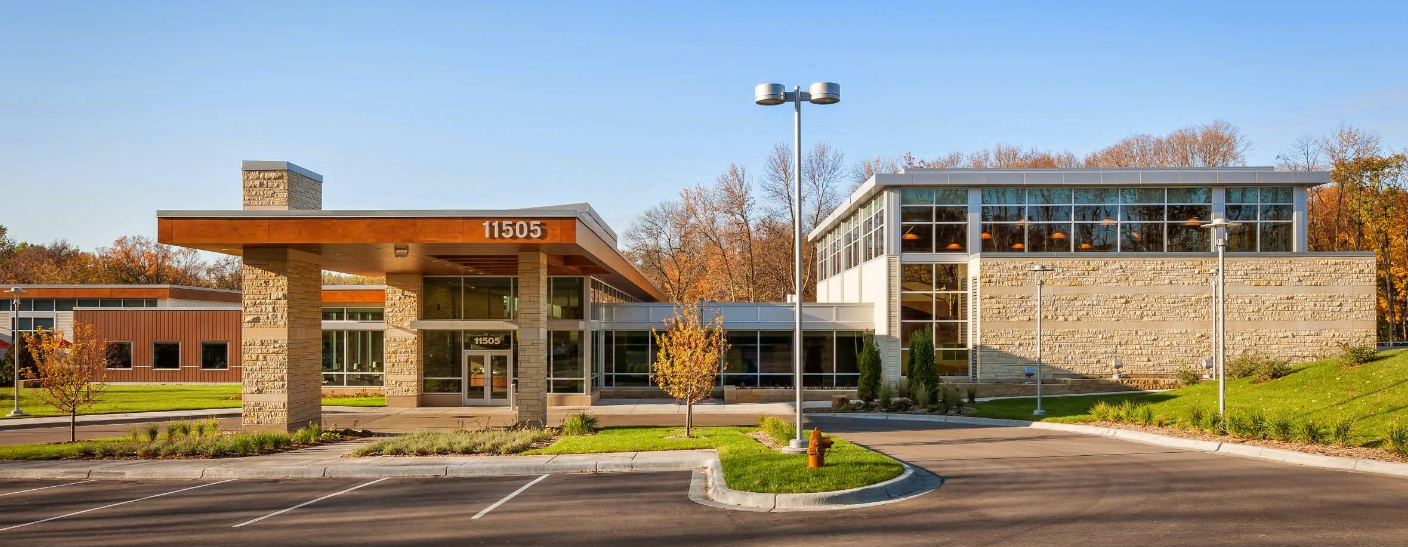 Modern treatment center exterior with covered entrance and parking