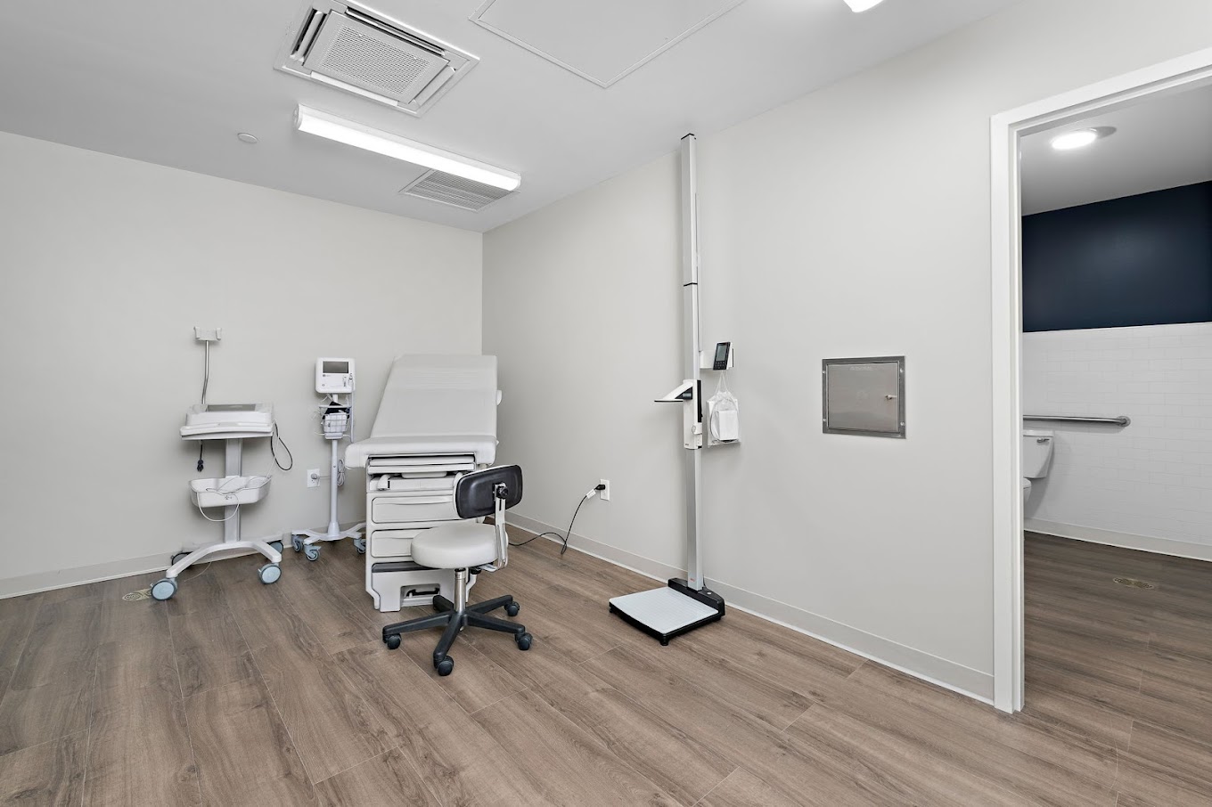 Exam room with scale, desk, and medical equipment