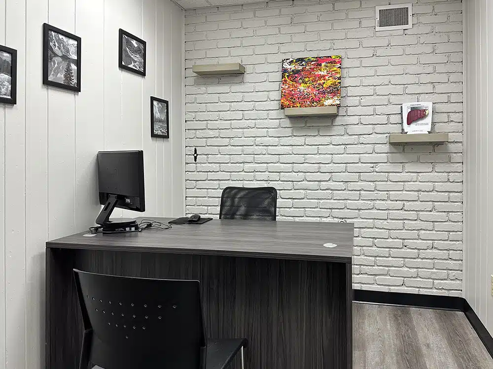 Small office with desk, chair, and white brick wall decor