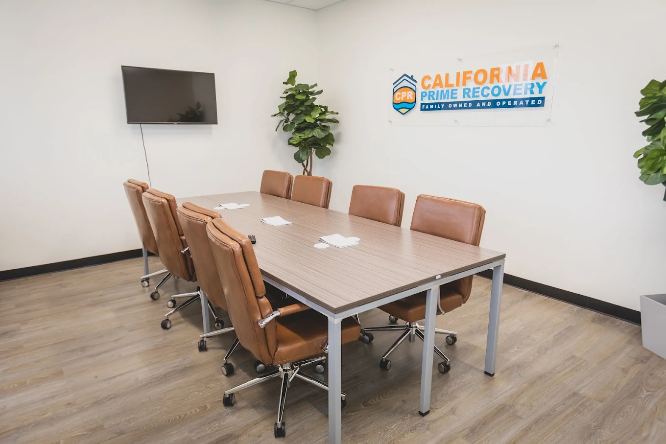 Conference room with table, chairs, and facility logo