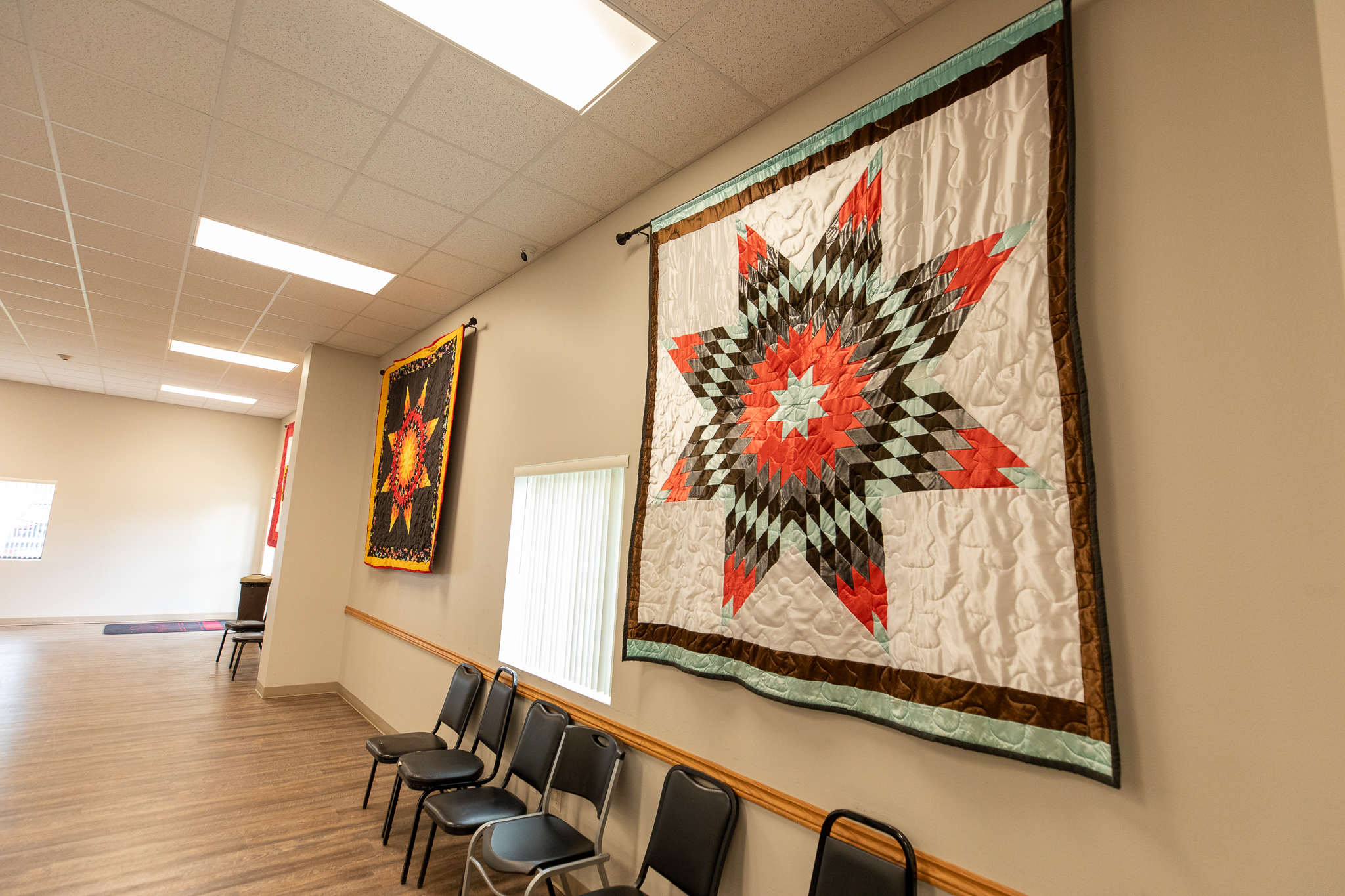 Large group room with rows of chairs and wall quilts