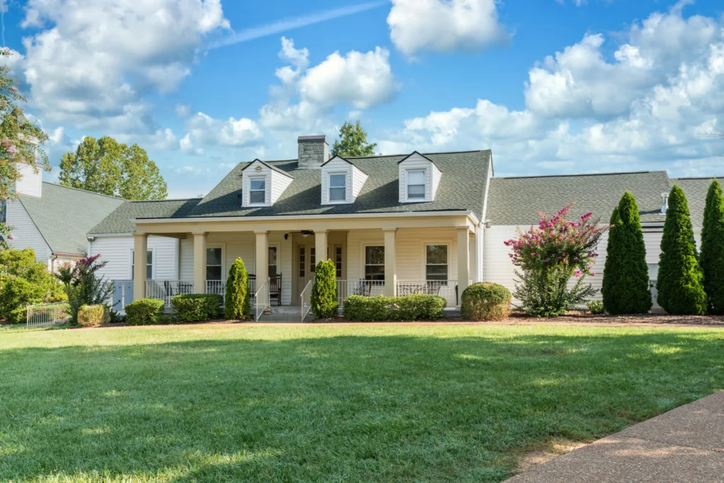 White residential-style building with porch and lawn