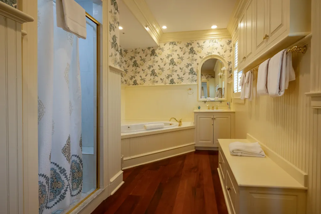 Private bathroom with tub, shower, and elegant decor