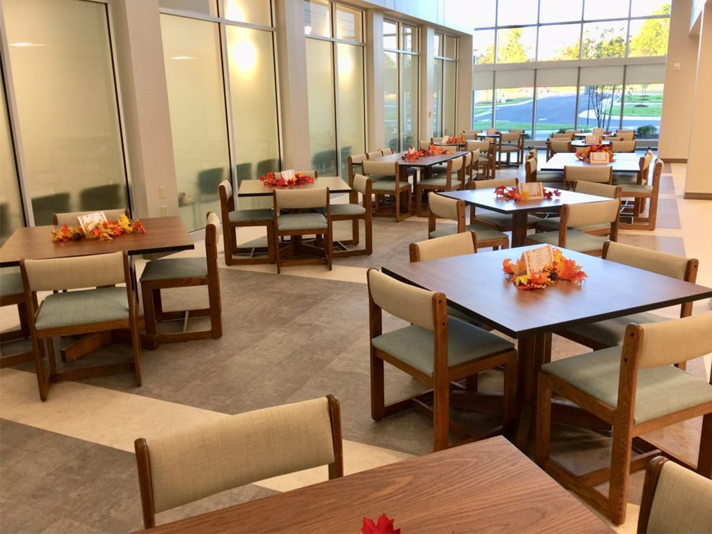 Dining area with tables, chairs, and large windows