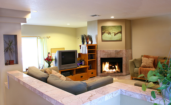 Comfortable lounge with sofas facing a lit stone fireplace