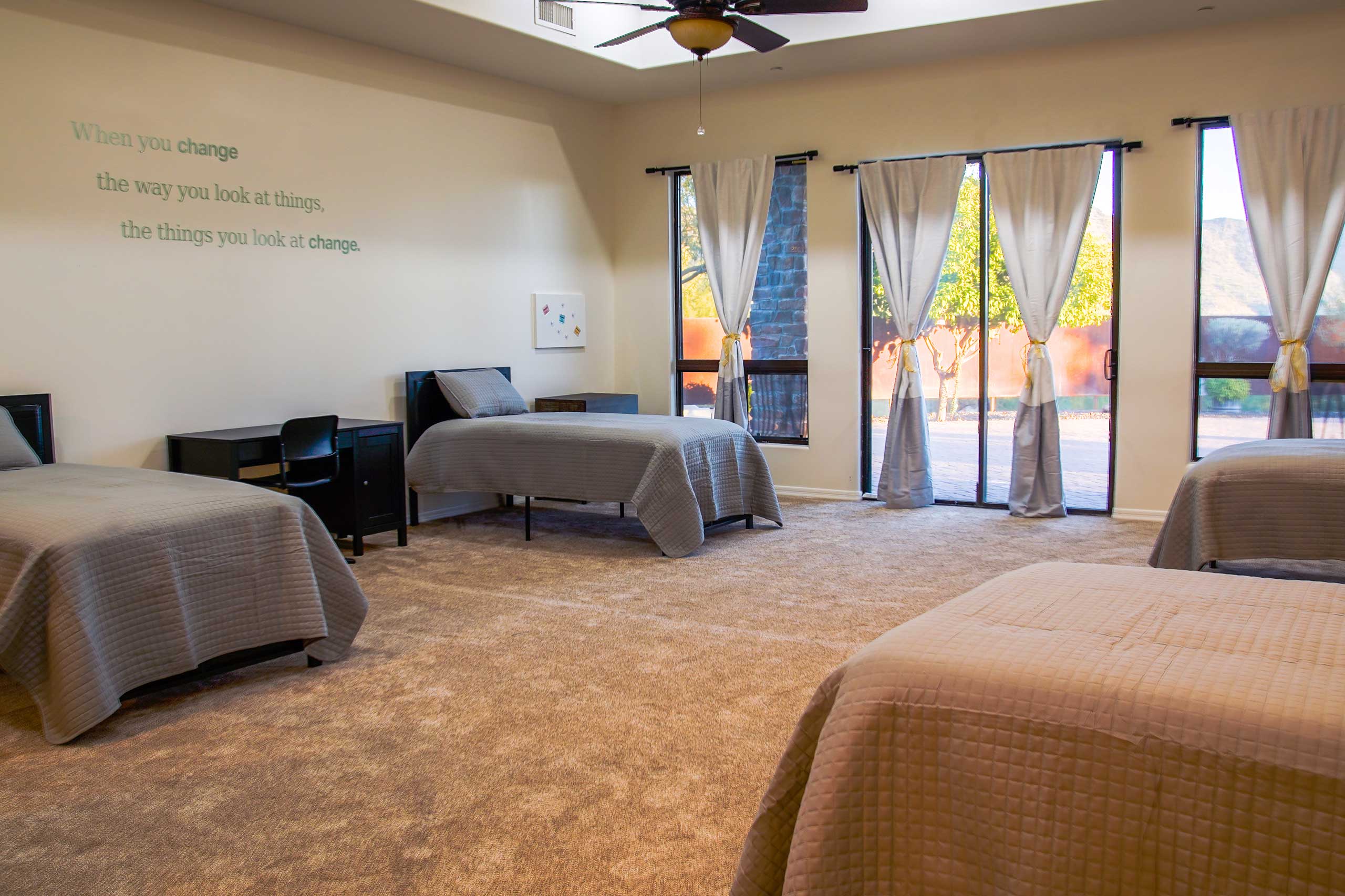 Shared teen bedroom with natural light and multiple beds