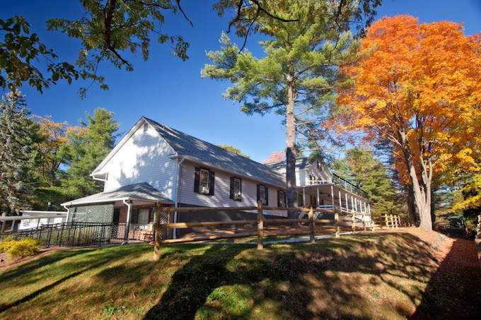 White two-story building with windows and trees