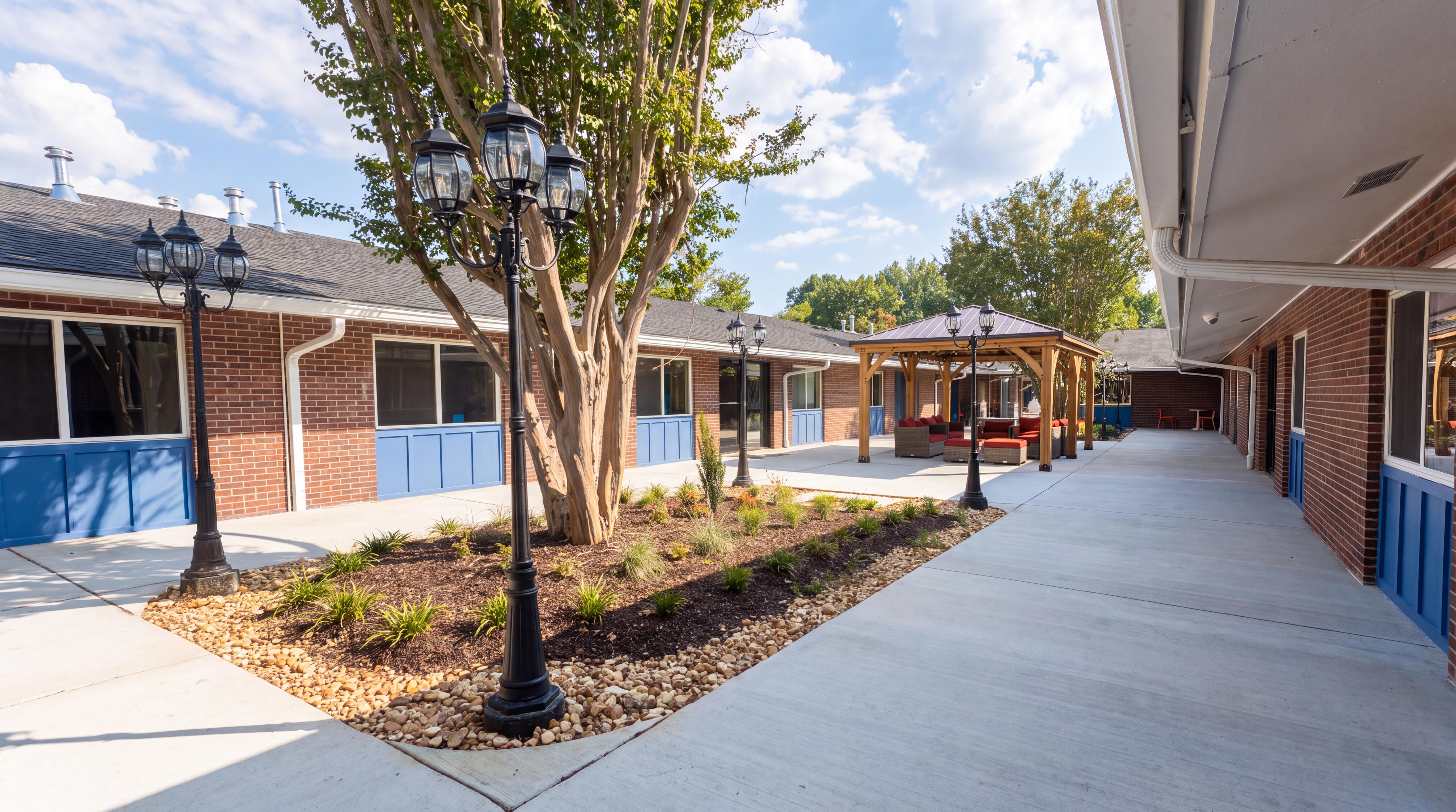 Paved courtyard walkway between buildings with trees