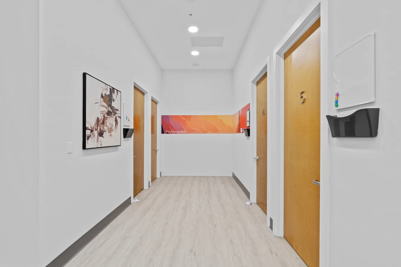 Bright hallway with wooden doors and modern wall art