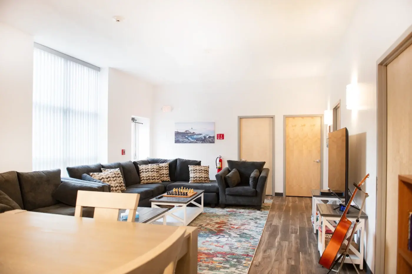 Lounge with gray sofas, TV, and a colorful rug