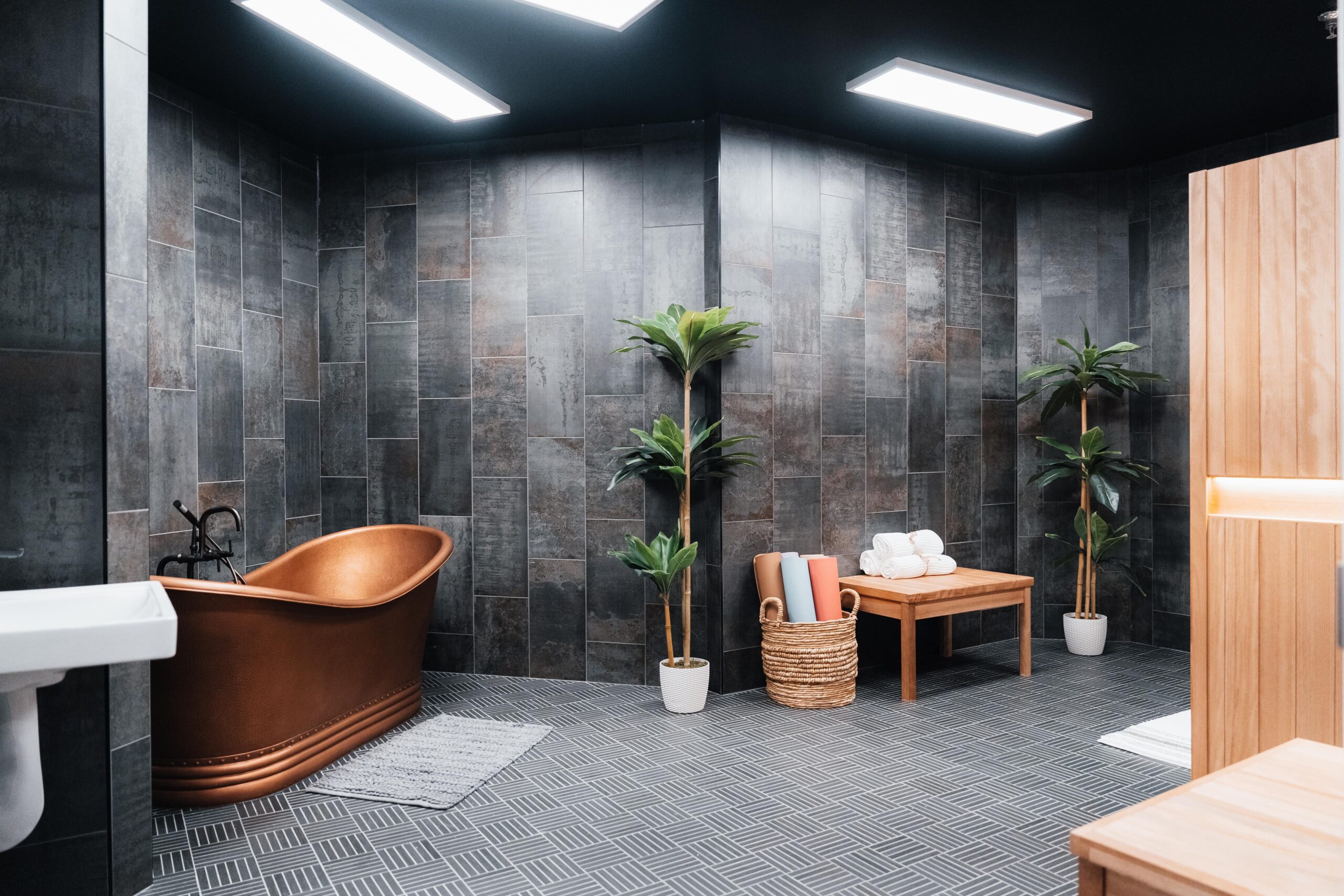 Modern bathroom with granite walls, plants and decor.