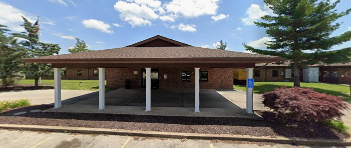 Covered front entrance of the facility with brick exterior and pillars
