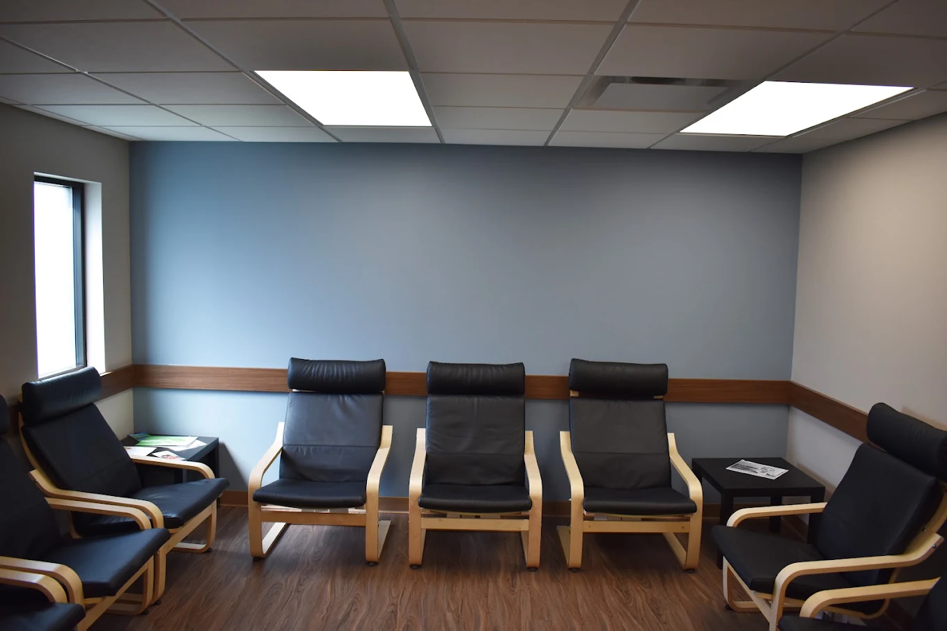Black chairs arranged around a small treatment seating area