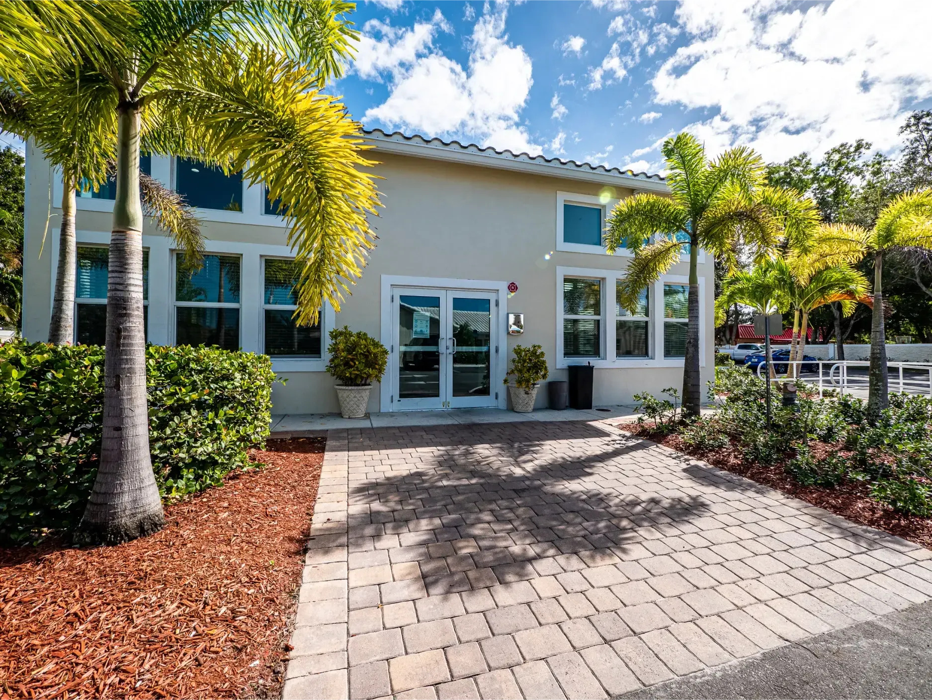 Front view of detox facility with palms and walkway.