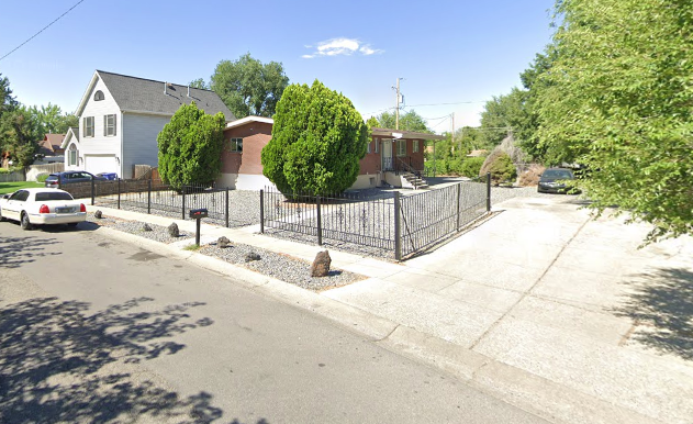 Residential home with fenced yard and trees