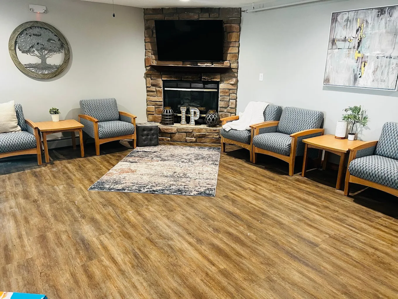 Common area with upholstered chairs and a stone fireplace