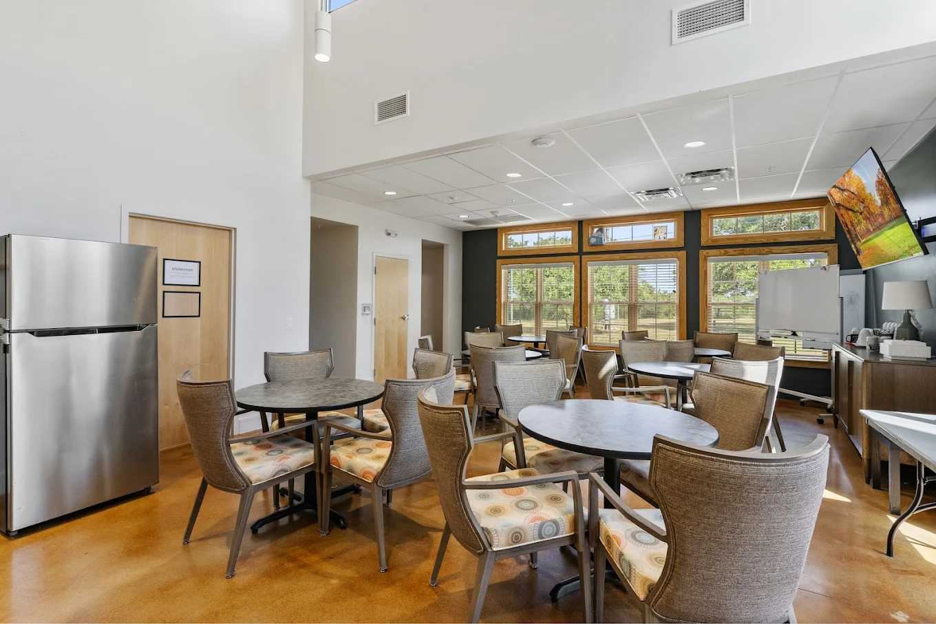 Dining area with tables chairs and large windows