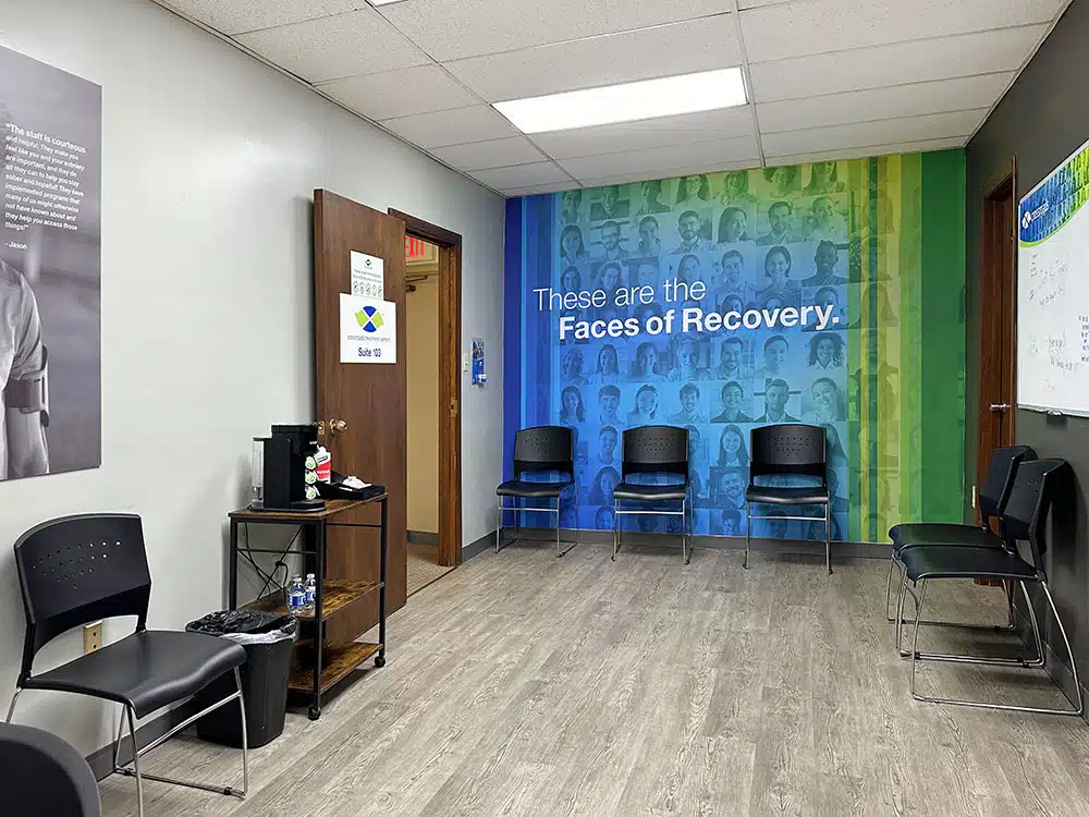 Waiting area with chairs and Faces of Recovery mural