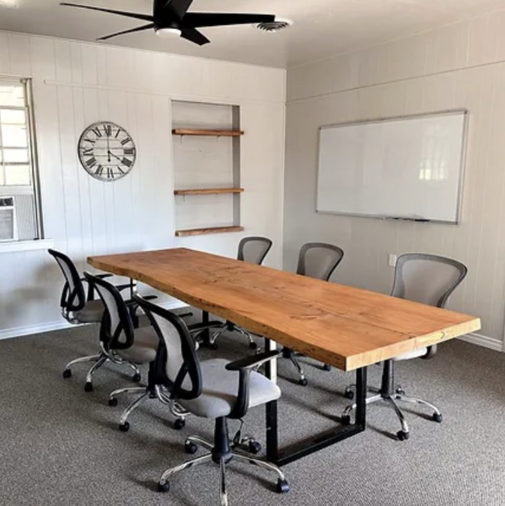 Dining area featuring a long table, whiteboard, and chairs.