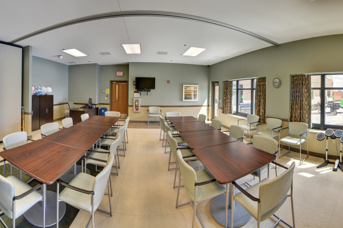 Group room with long tables, chairs, and TV