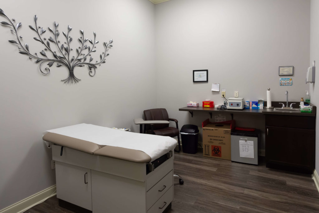 Medical exam room with bed and supplies.