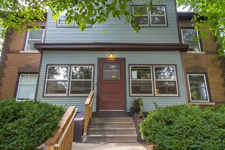 Two-story residential building with brown trim and front steps