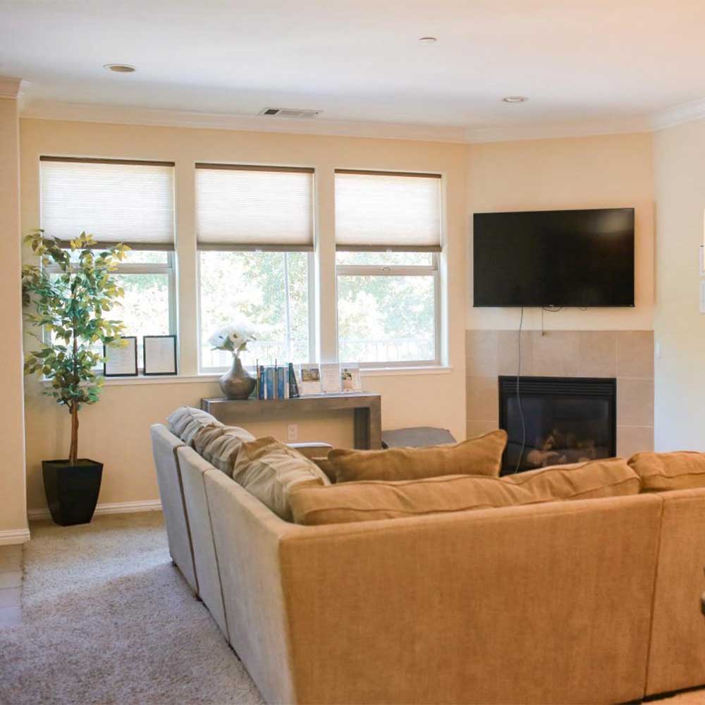 Lounge with beige sectional and wall-mounted TV