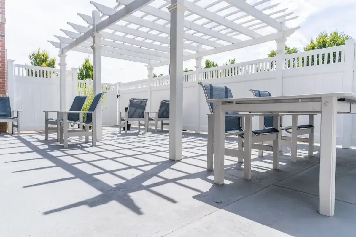 Patio with seating under a white pergola.
