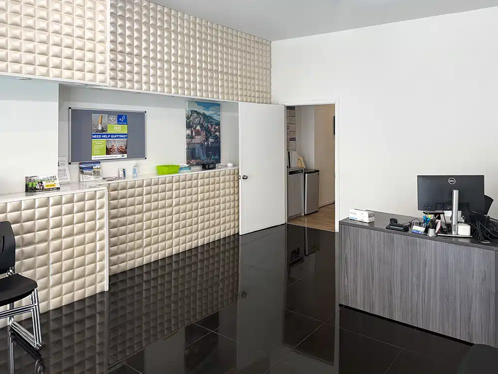Reception desk with padded wall panels and computer
