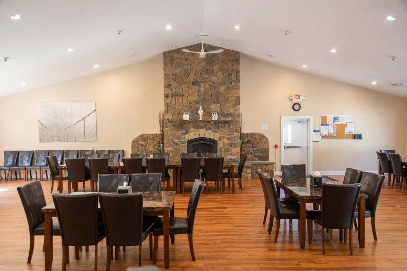 Dining tables and chairs near a stone fireplace