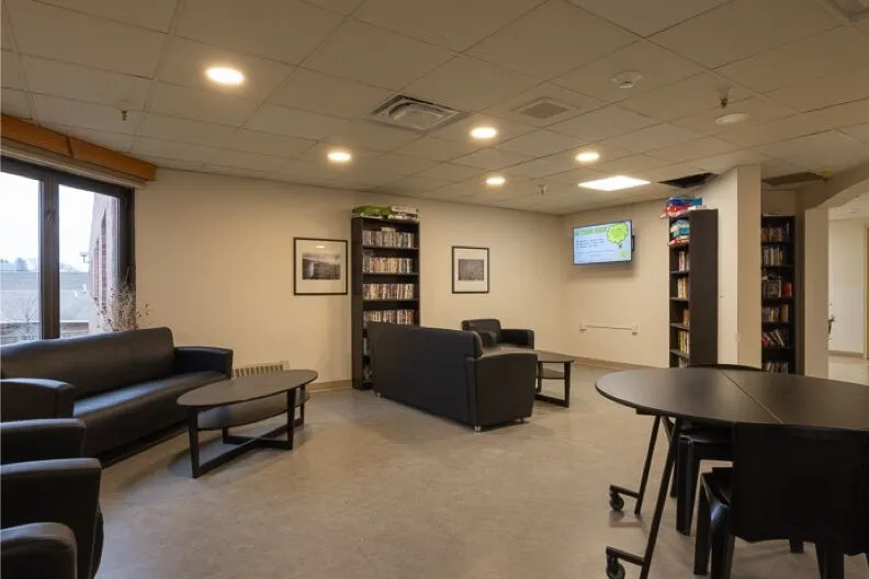 Common area with sofas, tables, and bookshelves