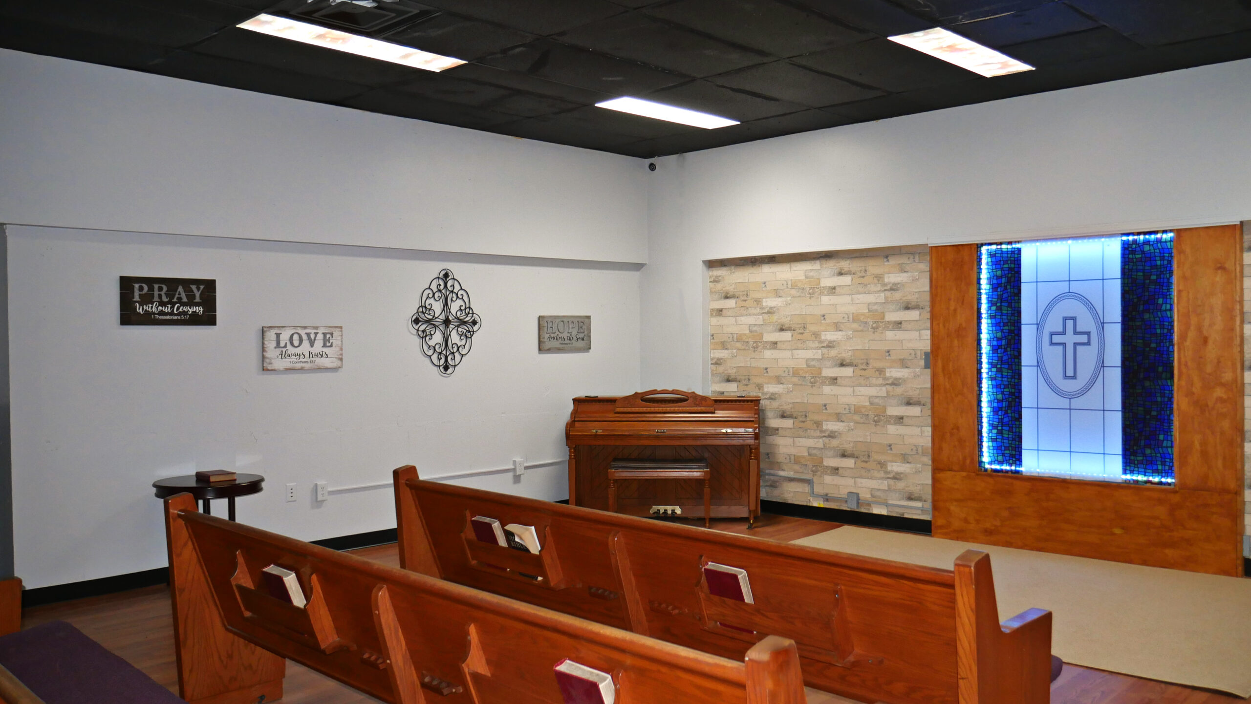 Small chapel with wooden pews and stained glass window