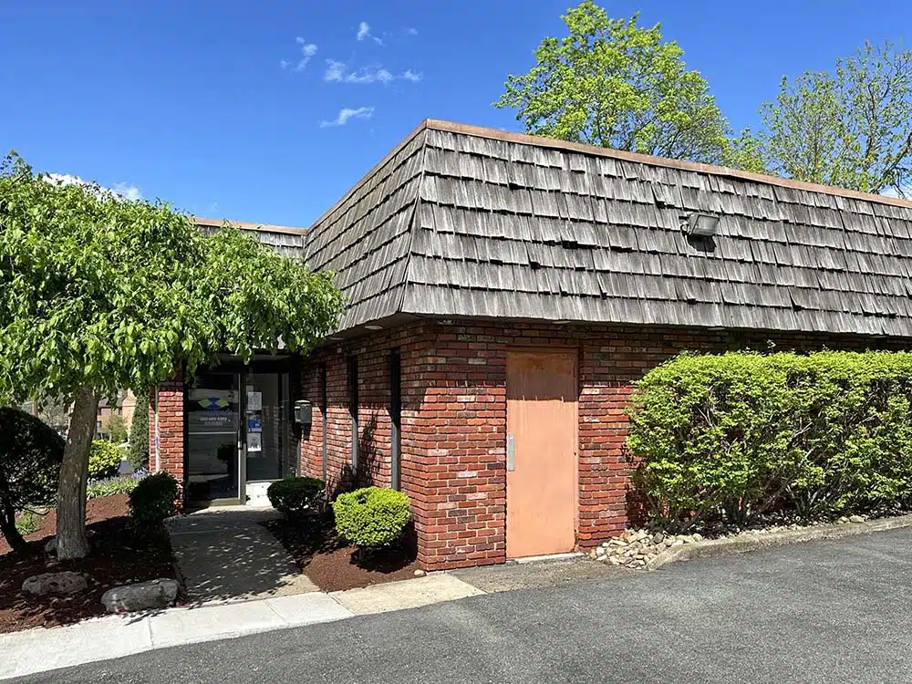 Brick clinic building with shingle roof and landscaped entry