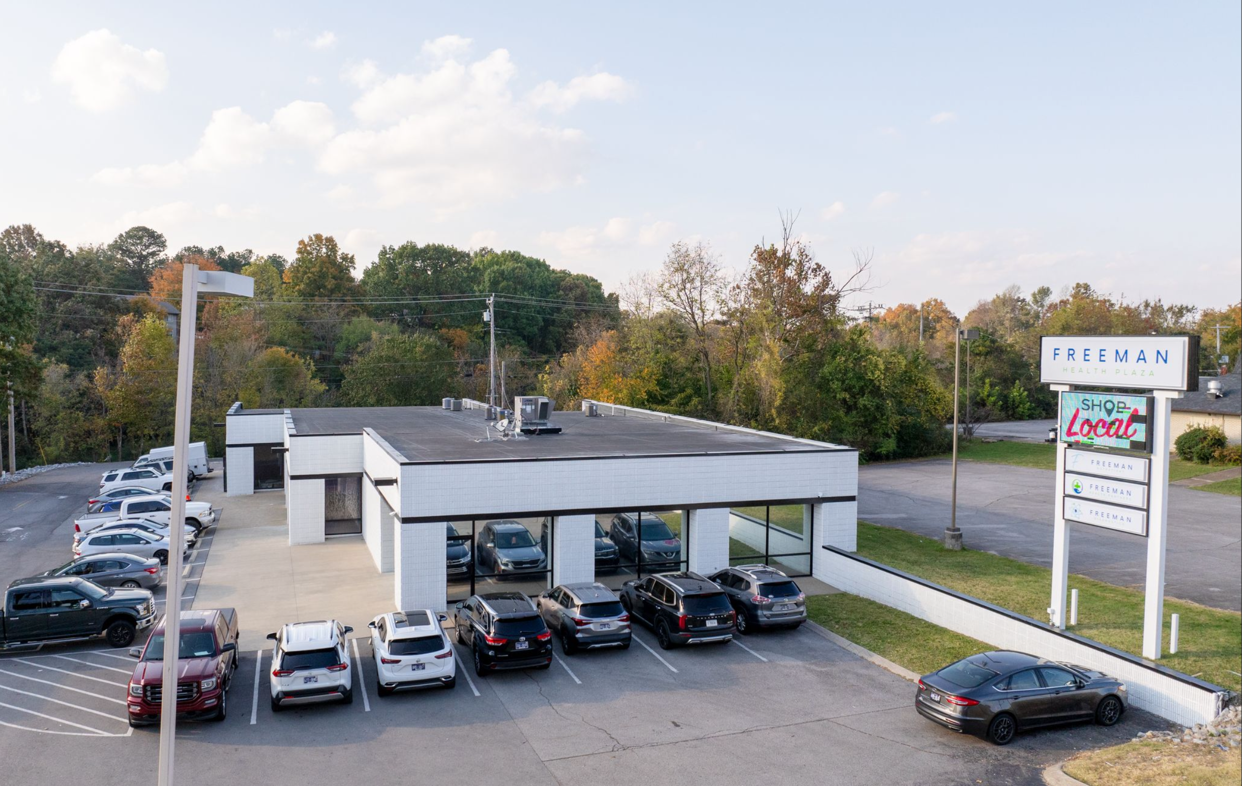 White brick outpatient building with parking lot and signage