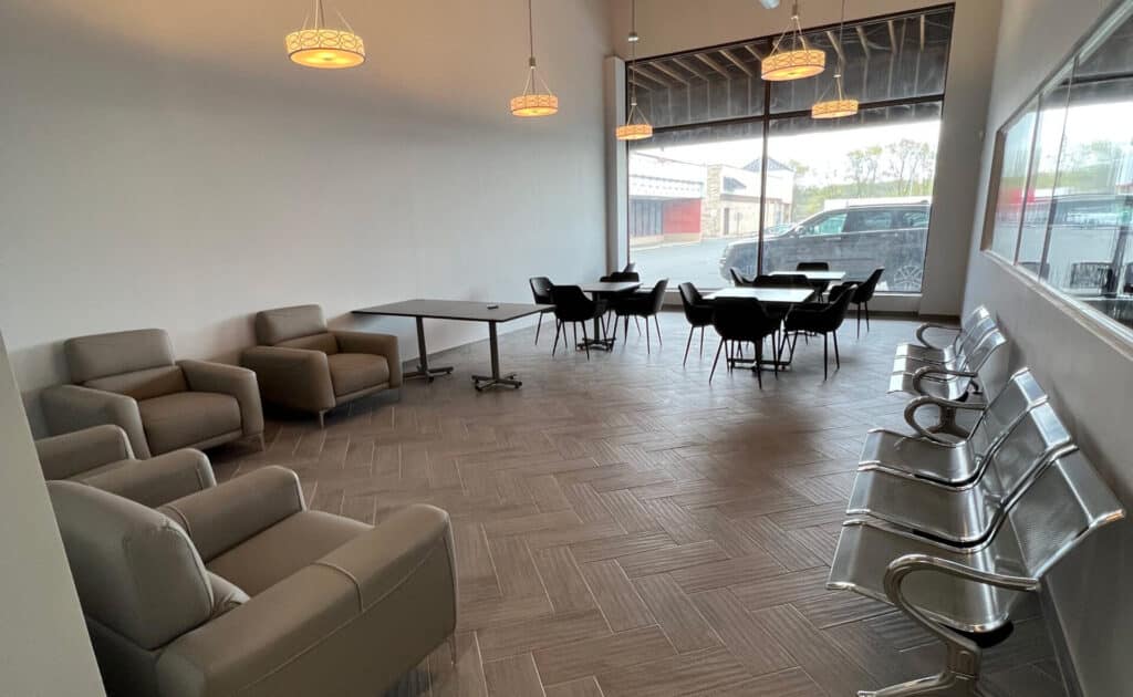 Well-lit therapy room with comfortable chairs and a whiteboard.