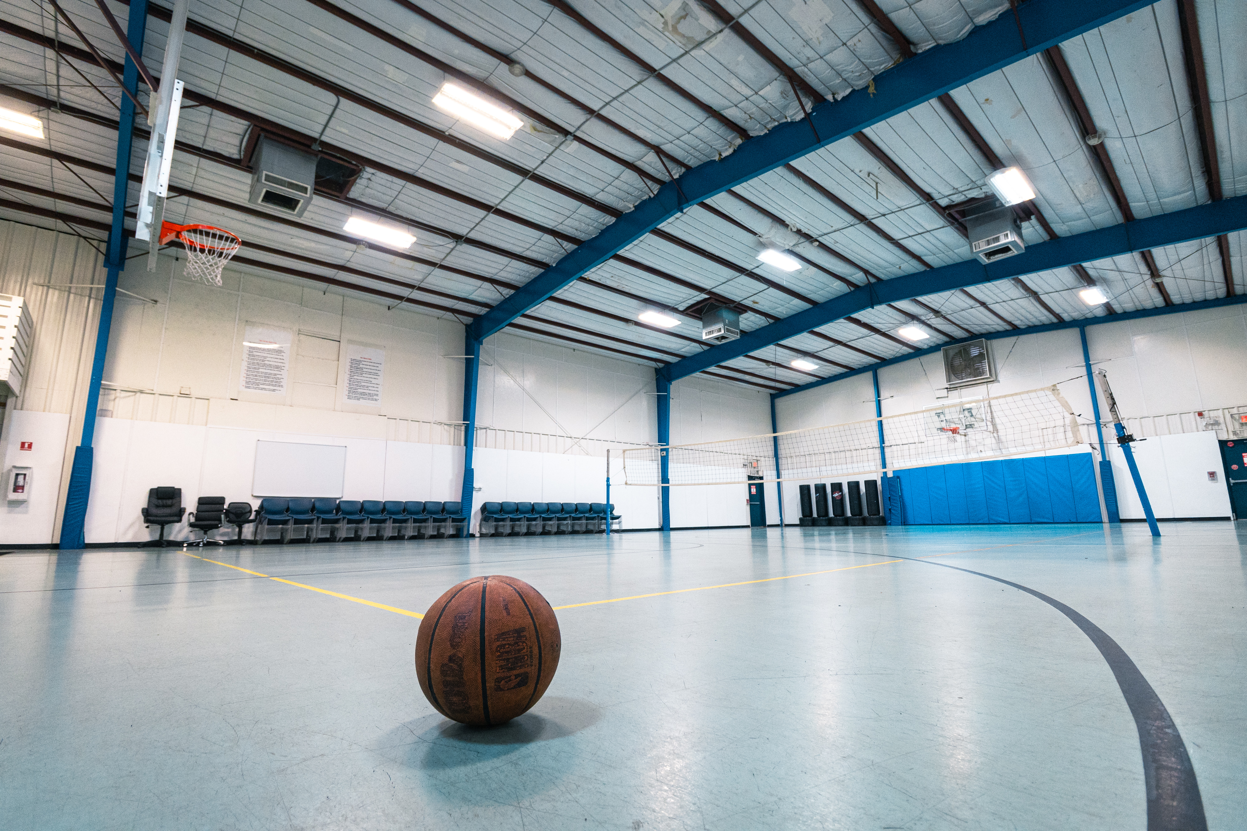 Indoor gymnasium with a basketball court and open recreational space.