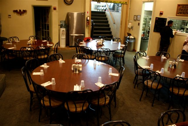 Cafeteria with round dining tables and serving area