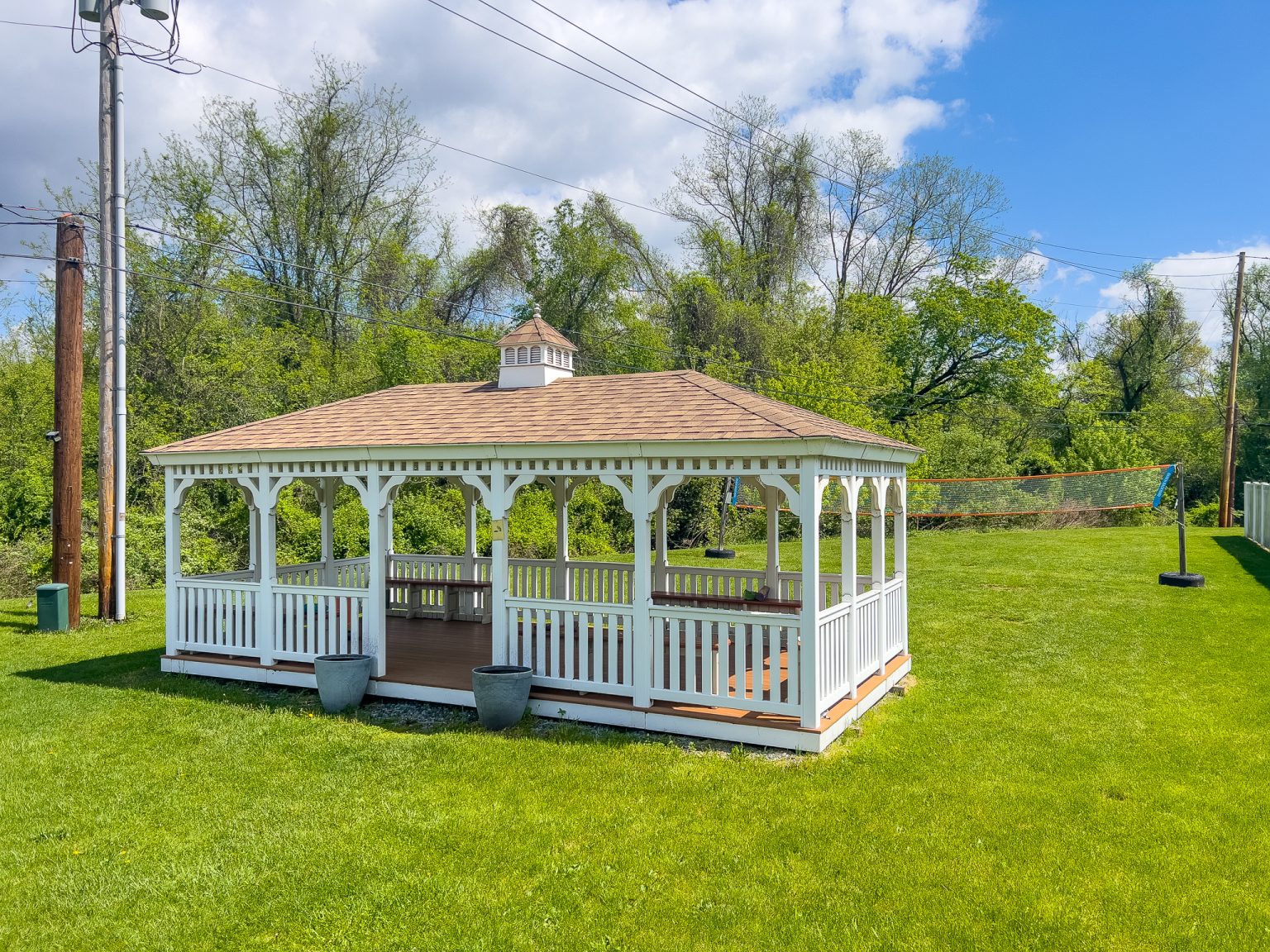 White gazebo on grass near volleyball net
