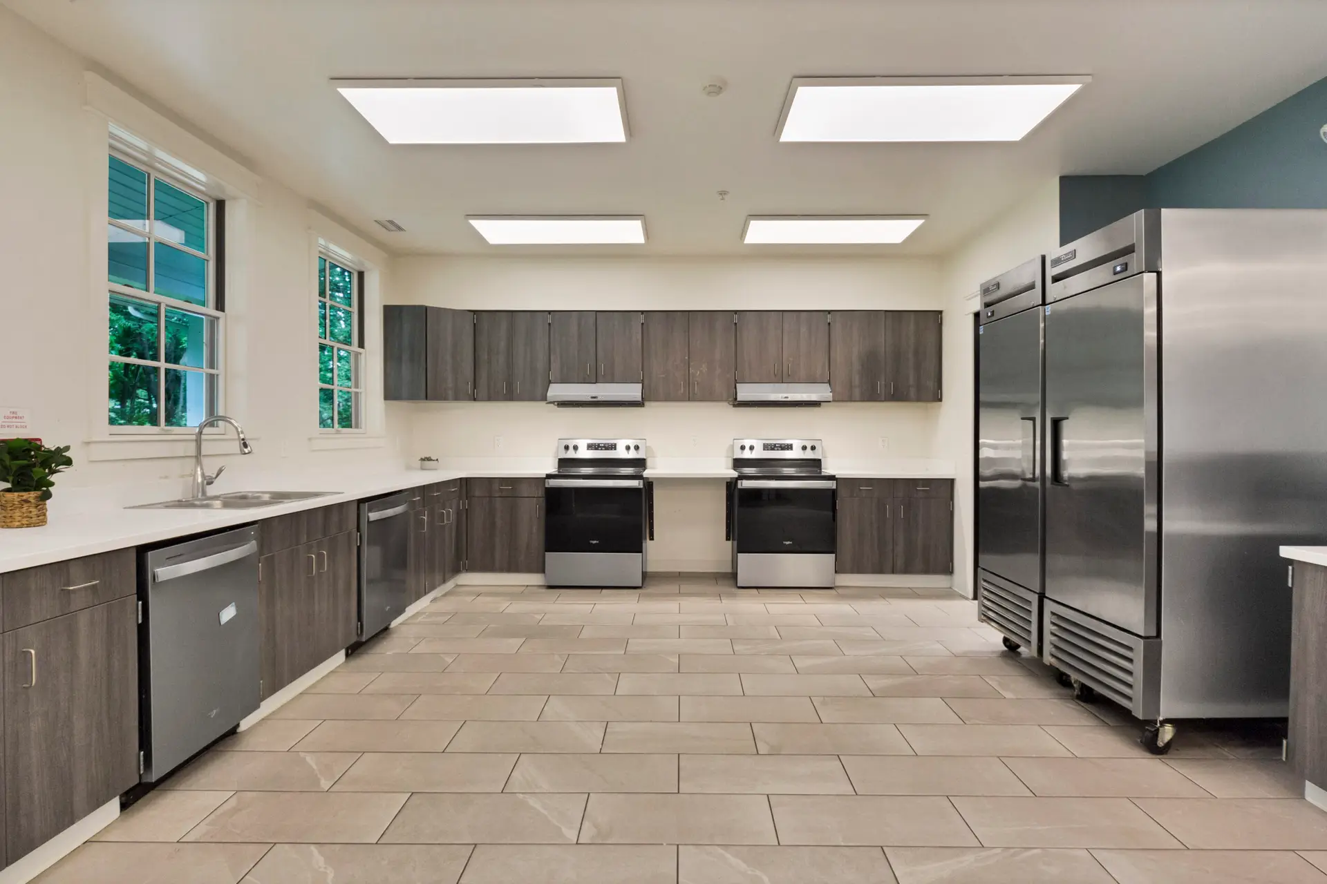 Commercial-style kitchen with stoves, cabinets, and refrigerators