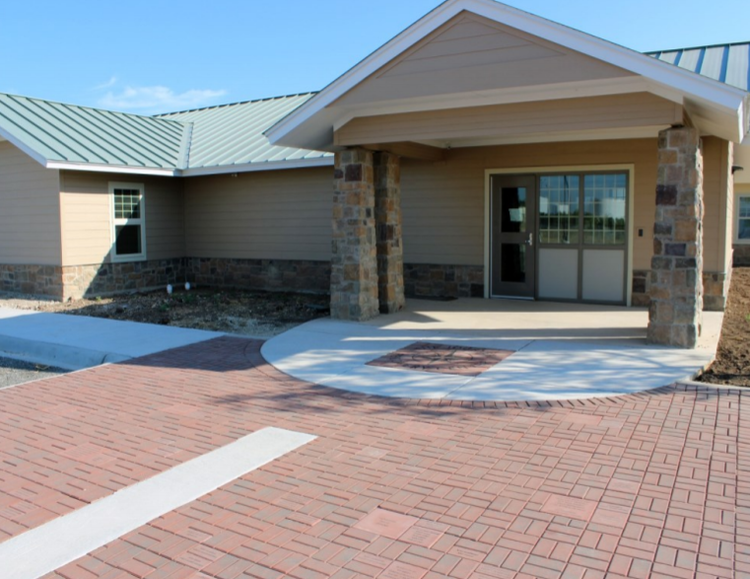Covered treatment center entrance with brick walkway