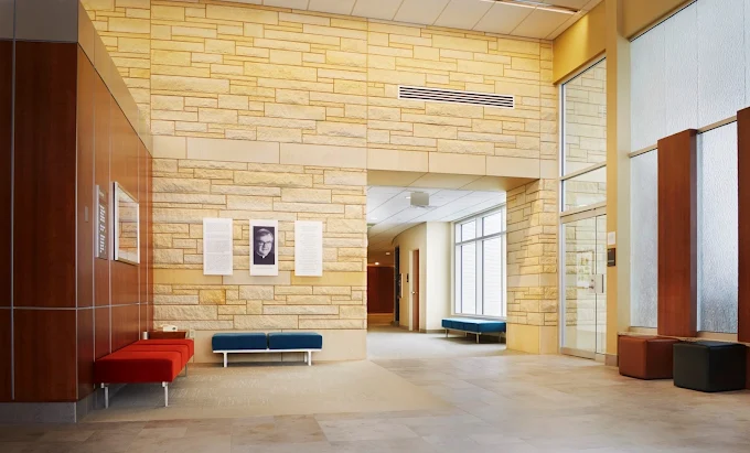 Bright lobby with stone walls, modern benches, and natural light