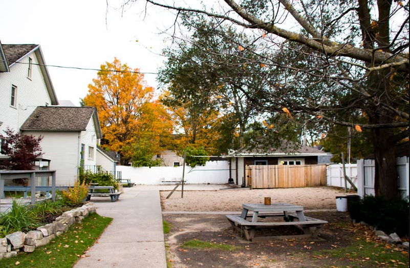 Outdoor yard with picnic tables and sand activity area